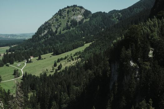 Experience the lush green landscapes of Füssen, Germany's picturesque Bavarian region from above.