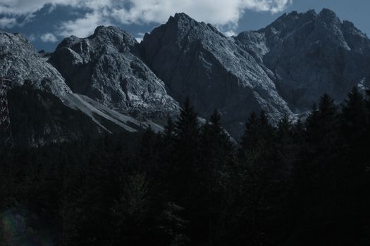 Stunning view of Garmisch-Partenkirchen's rugged mountains with dense forest foreground.