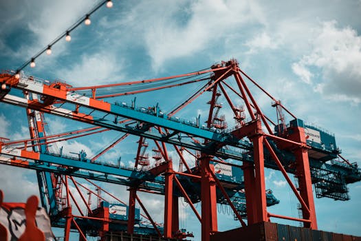 Dynamic view of industrial cranes at Hamburg port with a vibrant sky backdrop.