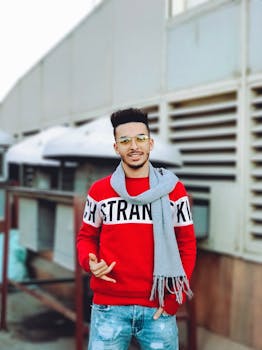 Stylish young man in casual winter attire posing outdoors in urban setting.
