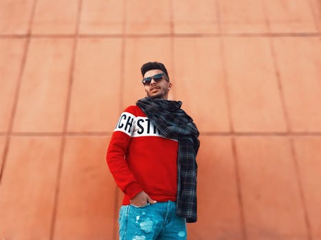 一位戴着太阳镜和围巾的时尚年轻人站在城市背景下，非常适合时尚和生活方式概念