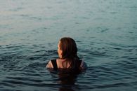 A serene moment of a woman swimming in Lake Vättern, Jönköping, Sweden, at dusk.