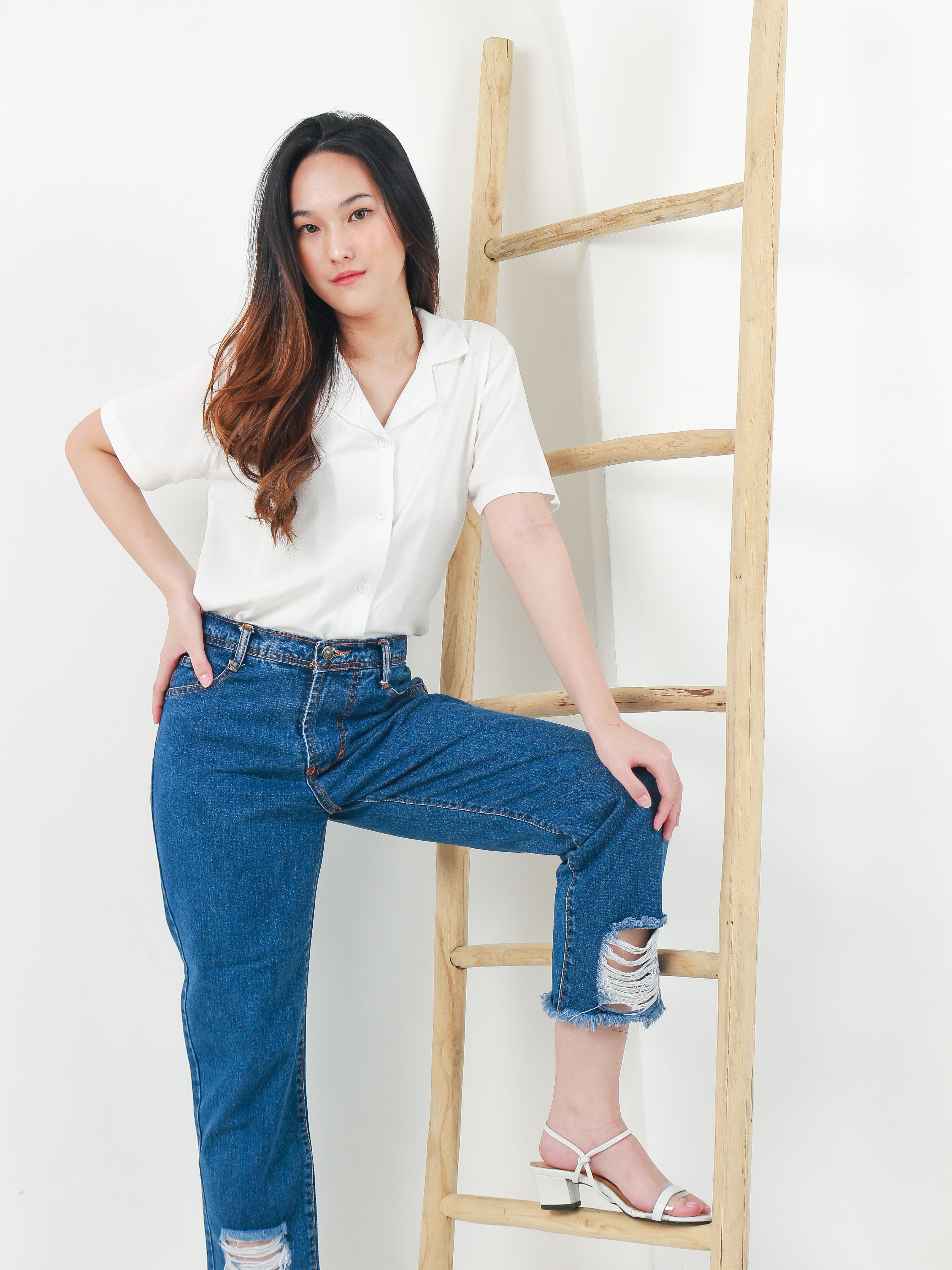 Woman in high-waisted jeans with silk blouse