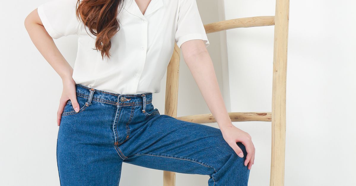 Woman in high-waisted jeans with silk blouse