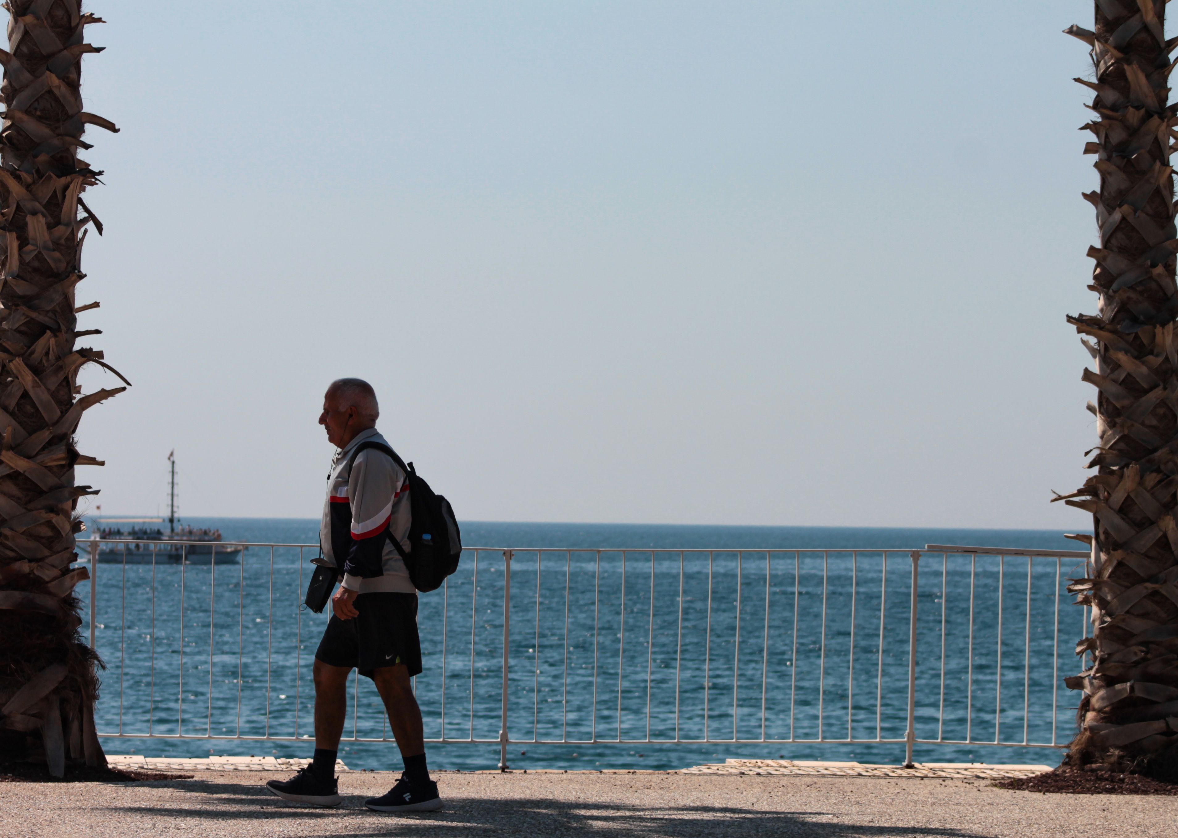 An older man walking comfortably outdoors after learning his enlarged prostate is benign
