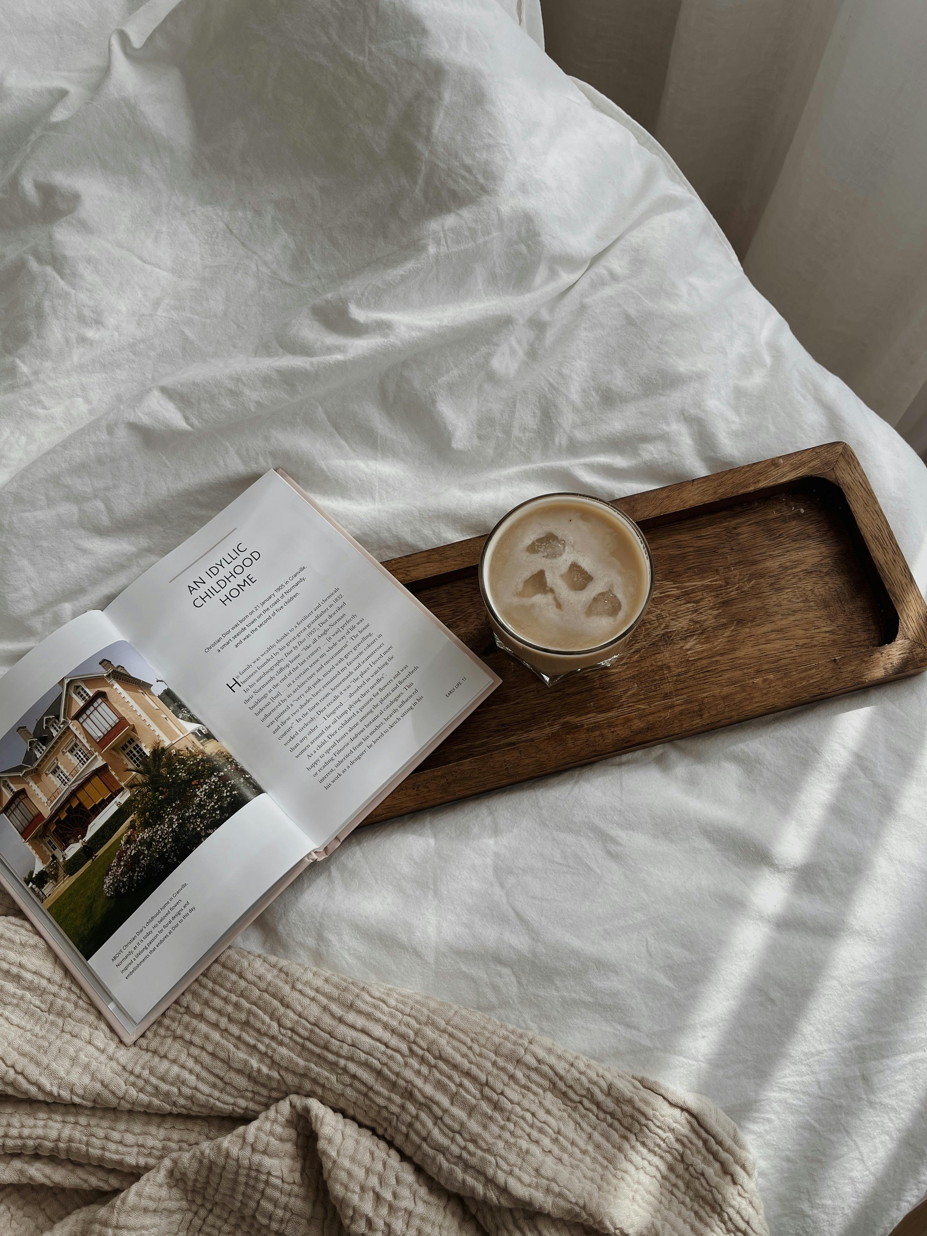 A serene morning scene with a coffee and magazine on bed, perfect for relaxation.
