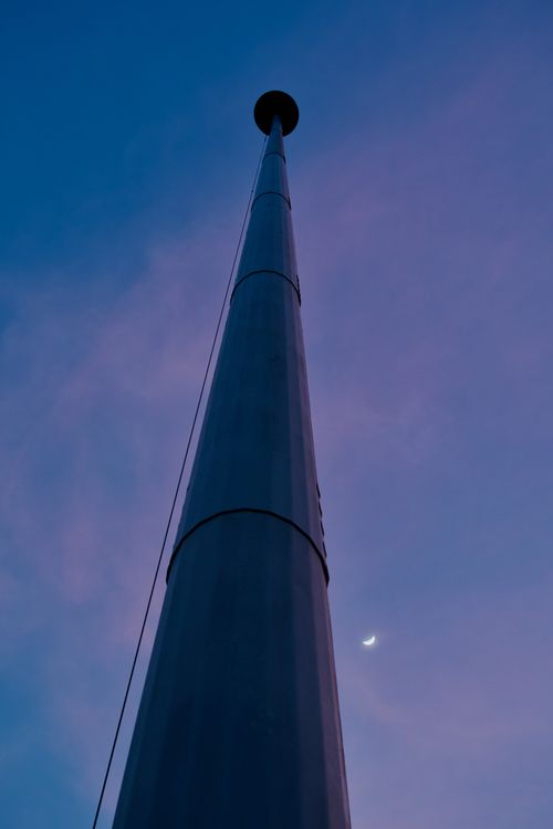 Free A towering structure reaching into a twilight sky with a crescent moon visible. Stock Photo