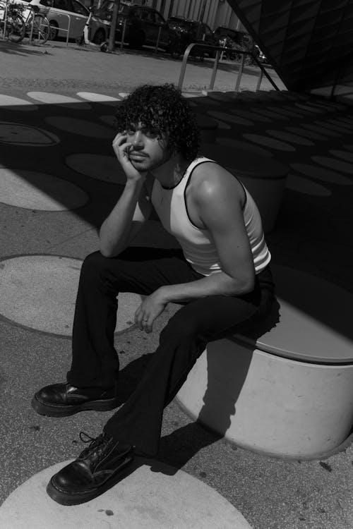 Young Man with Moustache Sitting Posing on City Street