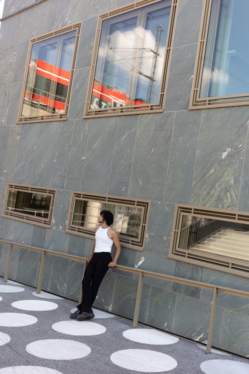 Young Man Standing near Building Wall
