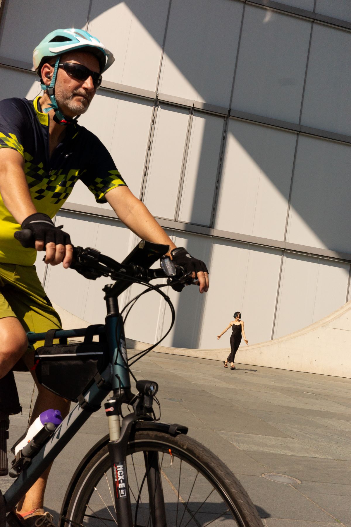 Urban cyclist wearing a helmet near modern architecture