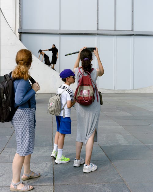 Group of Tourists with Backpacks near City Modern Building