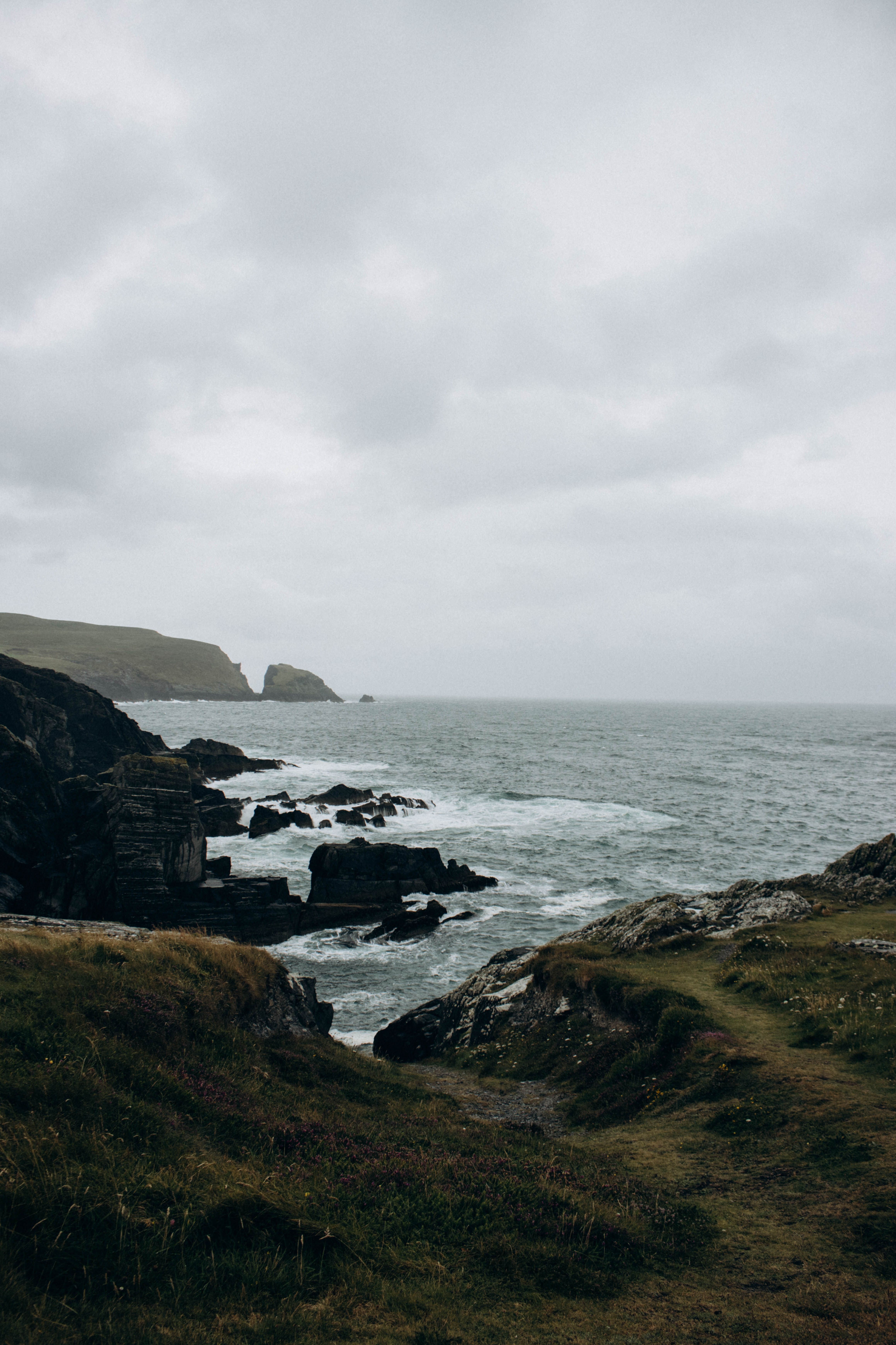 View of a Rocky Shore under a Cloudy Sky · Free Stock Photo