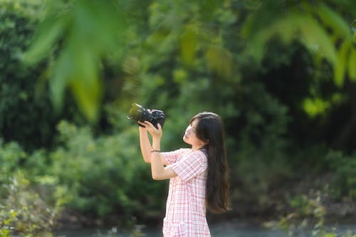 Cute Young Woman Taking Photo in Park