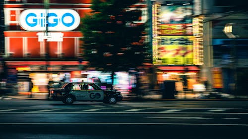 Blurred Motion of a Car Driving Fast on the Background of Illuminated Buildings 