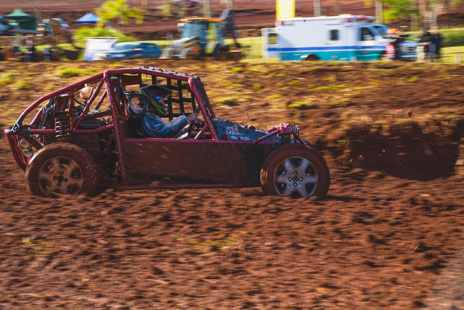High-speed off-road buggy race on muddy track, capturing thrilling motorsport action.