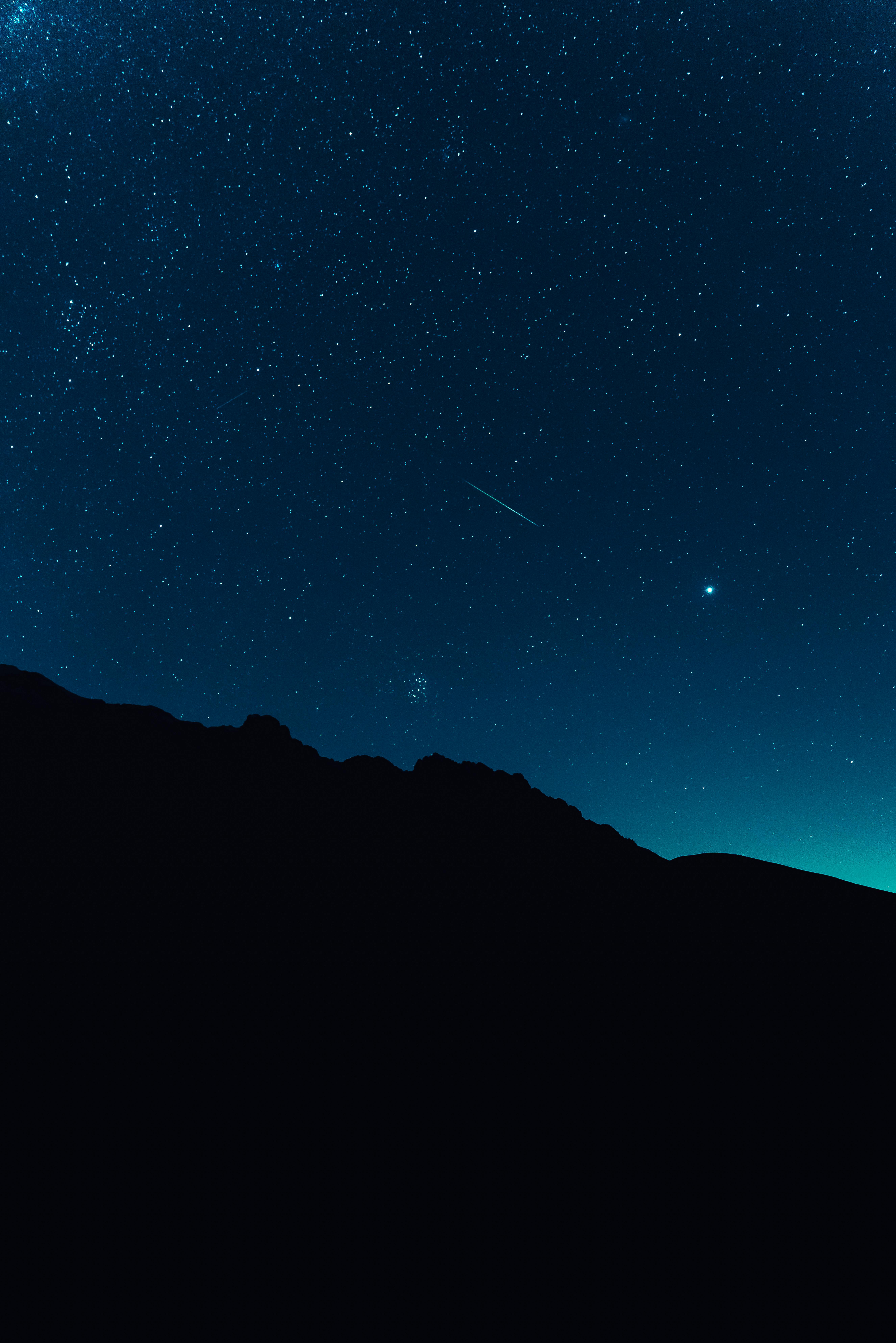 Silhouette of mountains under a starry night sky in Abruzzo, Italy.