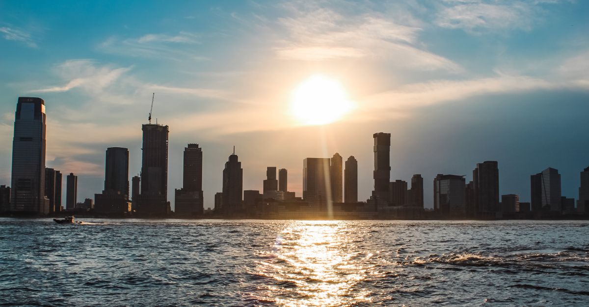 sunrise over city skyline with coffee cup in foreground