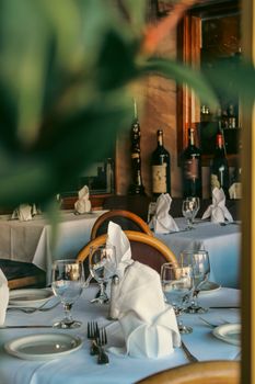 Sophisticated dining table arrangement with glassware and wine bottles in a cozy restaurant setting.
