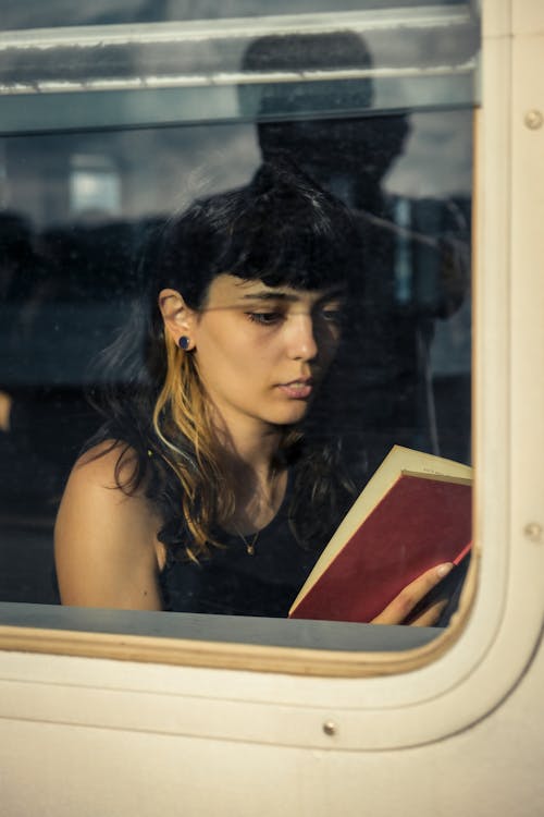 Woman behind Window Reading Book