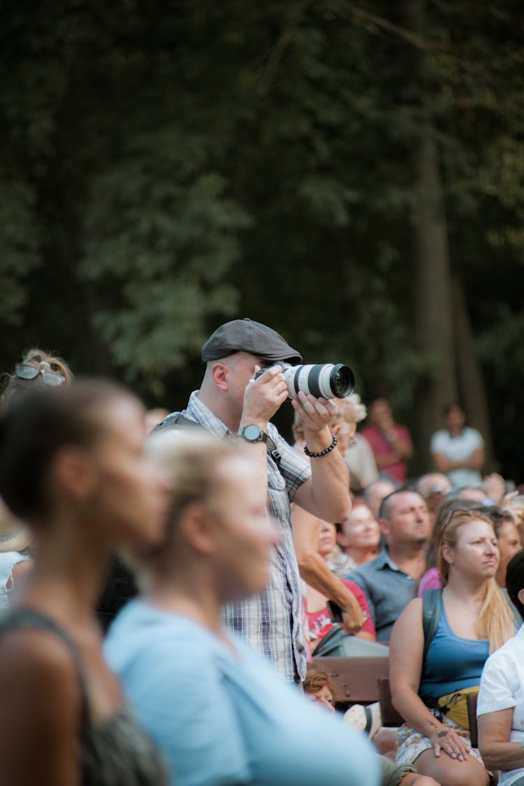 Photographer Taking Pictures Among People On Event