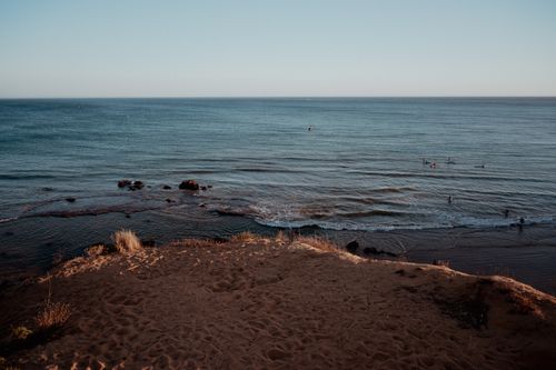 Free Tranquil beach scene with gentle waves under a warm sunset, perfect for relaxation. Stock Photo