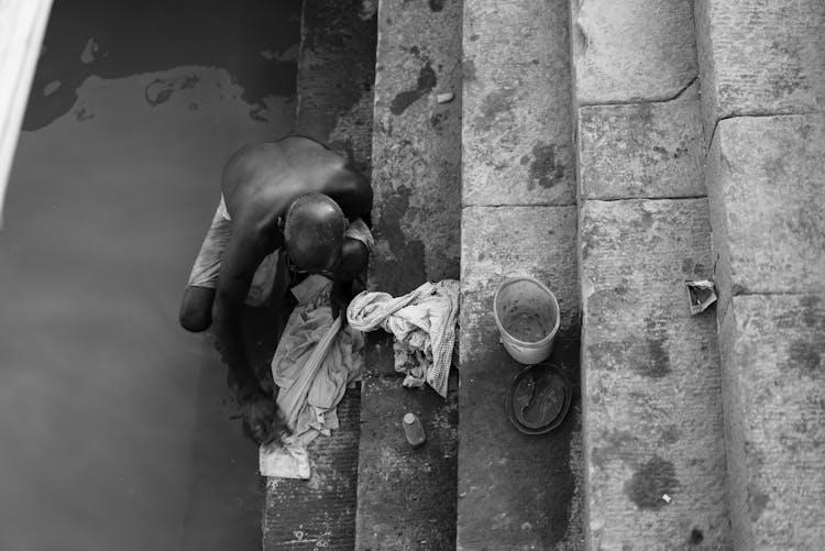 Man Washing Clothes In Water