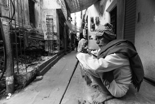 Elderly Man Wearing a Gown in a Narrow Street in India in Black and White 