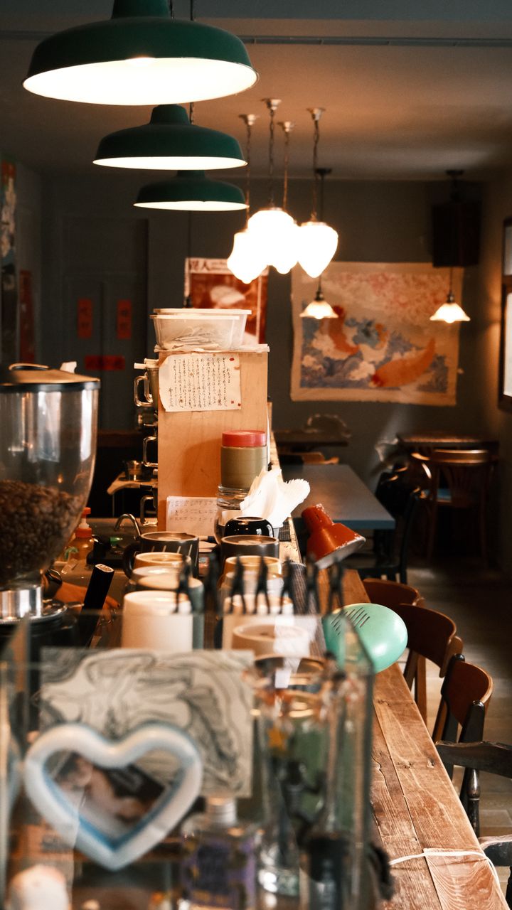 Row of glass jar pendant lights hanging above a farmhouse coffee bar with wooden counters