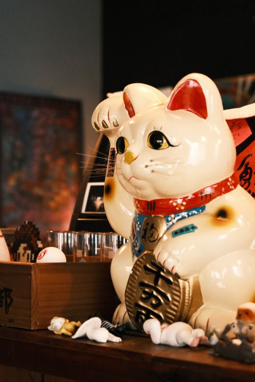 Free Close-up of a classic lucky Maneki Neko figurine with other toys. Stock Photo