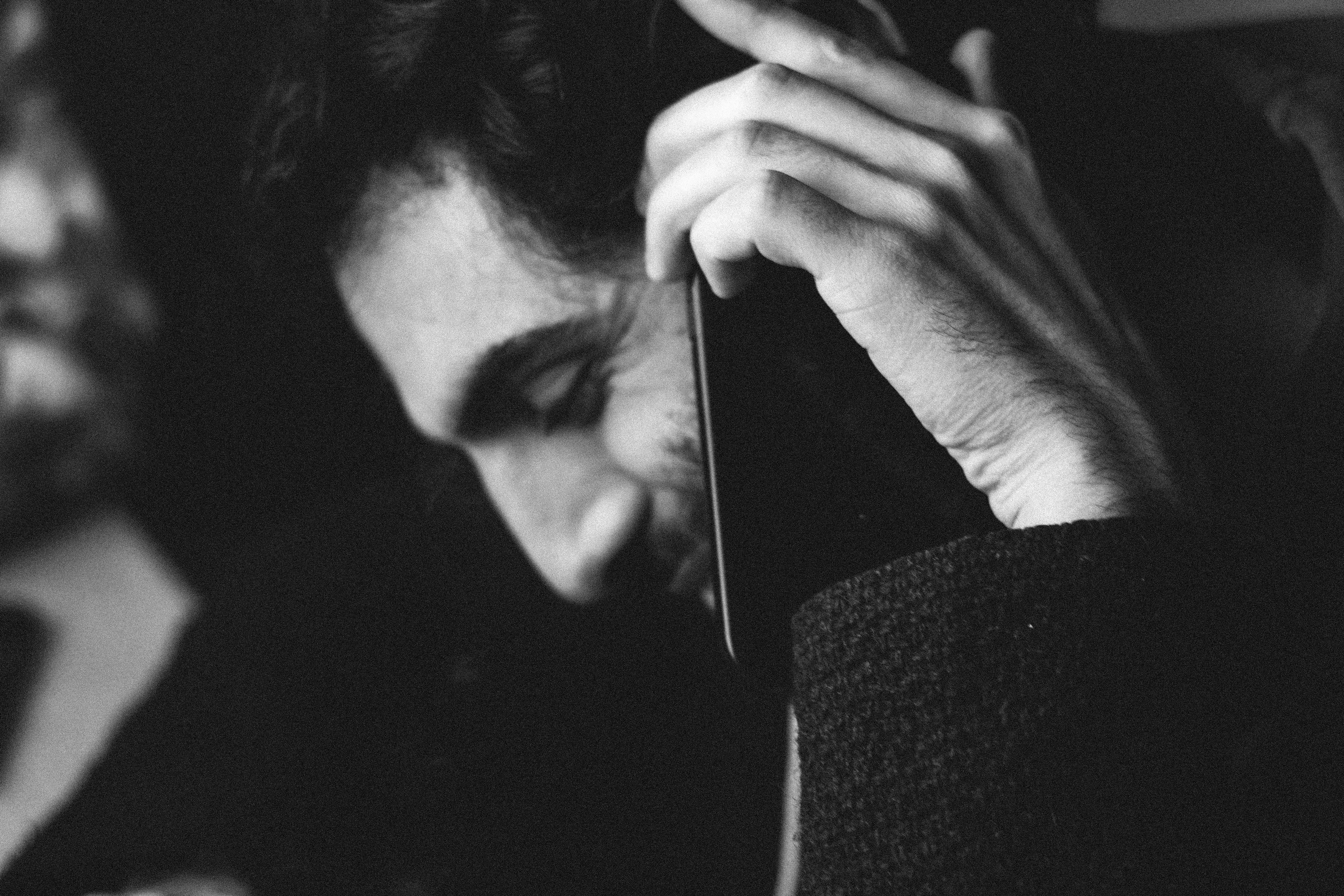 Black and white portrait of a man smiling while on a phone call, creating a relaxed mood.
