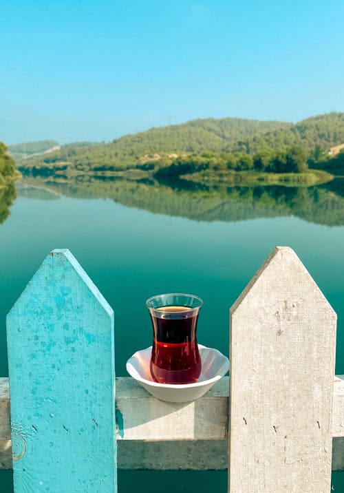 Glass of Tea against Lake in Summer