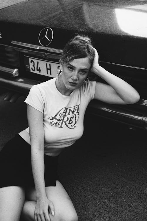 Model in a Lana Del Rey Crop Top and Mini Skirt Sitting on the Street Leaning Against the Bumper of a Car