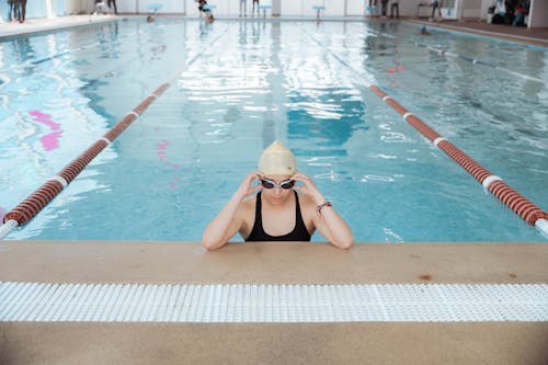 A Woman Wearing a Swimming Cap and Goggles in the Pool 