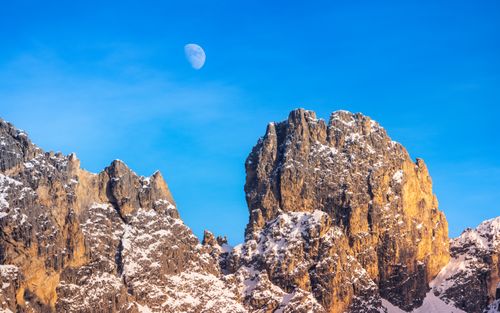 Free Stunning view of snow-covered Dolomite mountains at dusk with the moon in a clear blue sky. Stock Photo