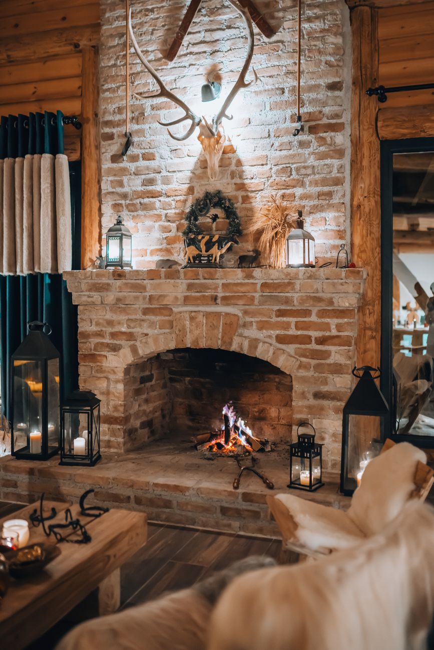 A warm, rustic living room featuring a brick fireplace and cozy decor.