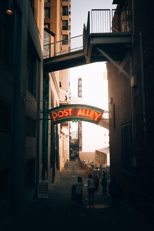 Free Atmospheric view of Post Alley in Seattle with people and sunset glow. Stock Photo