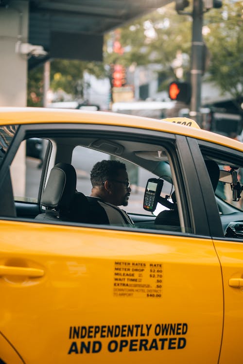 A man in a yellow taxi cab