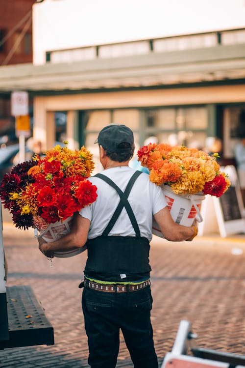 A man carrying flowers on his back