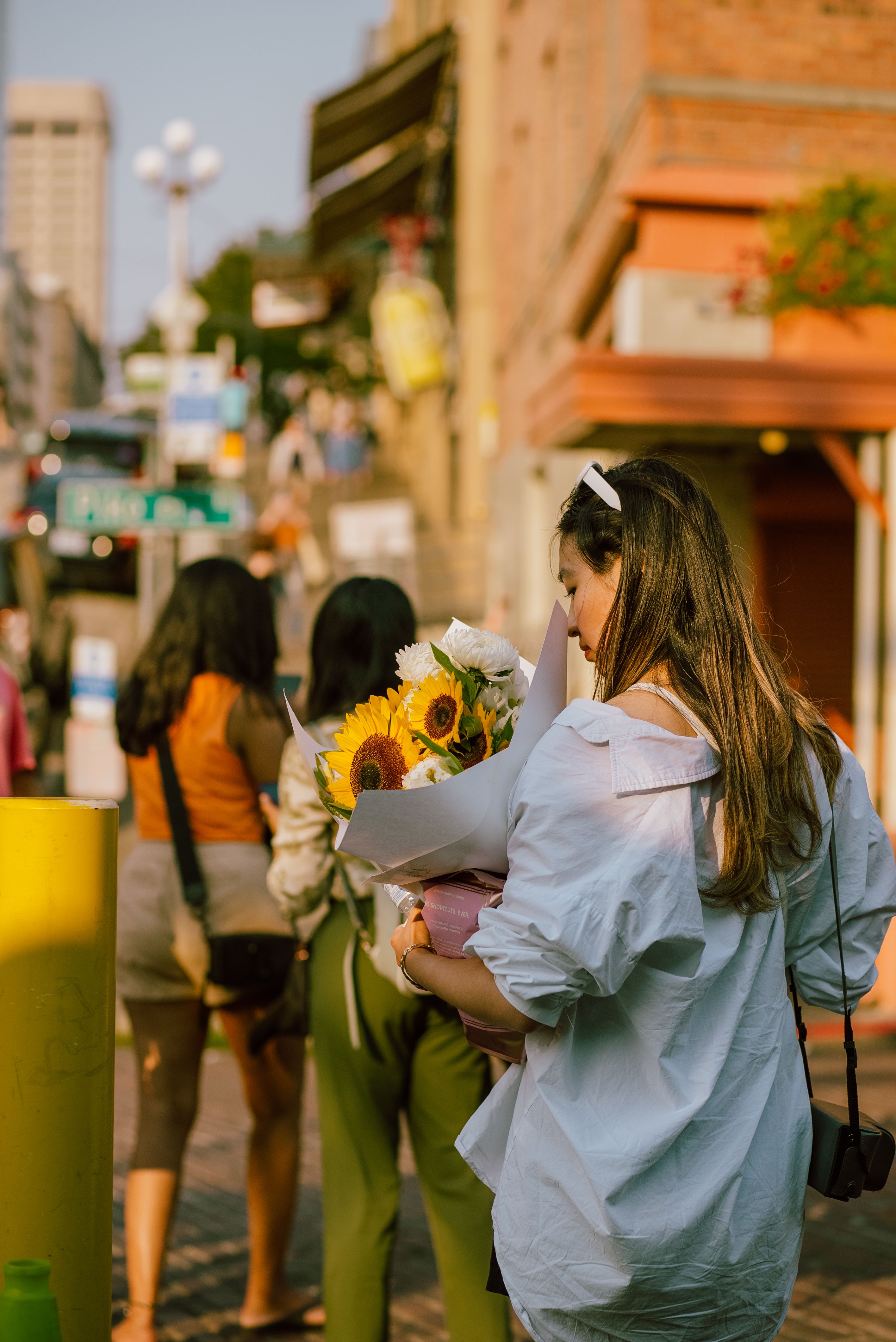 A woman is walking down a city street with a bouquet of flowers · Free ...