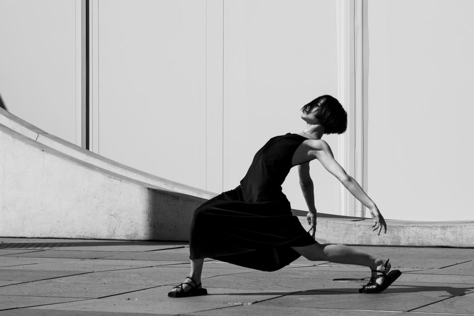 Stylish woman posing dynamically on urban pavement in Berlin.