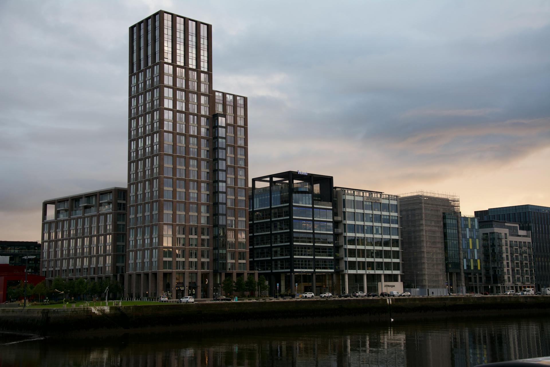 A sleek cityscape view of modern buildings along Dublin's waterfront at twilight.