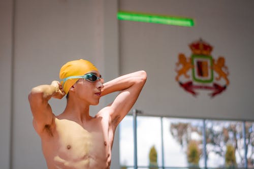 Swimmer Standing in Cap and Goggles