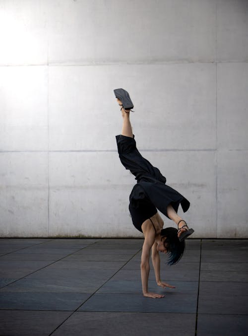 Woman in Black Dress in Handstand