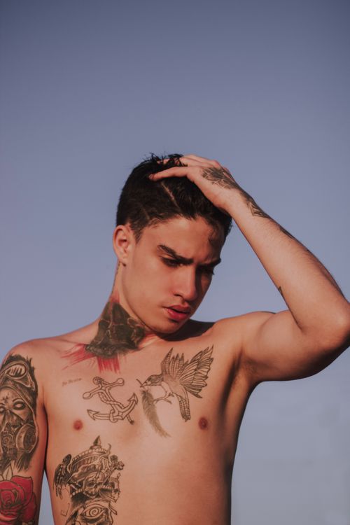 Free Young man with tattoos, posing thoughtfully under clear sky. Stock Photo
