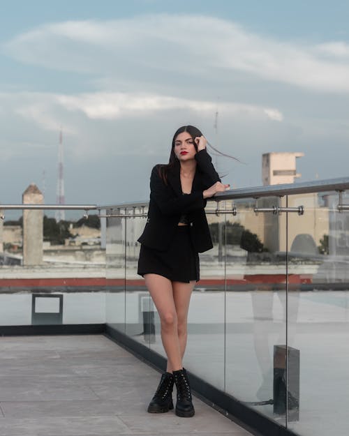 Model in Black Mini and Boots Posing on Rooftop