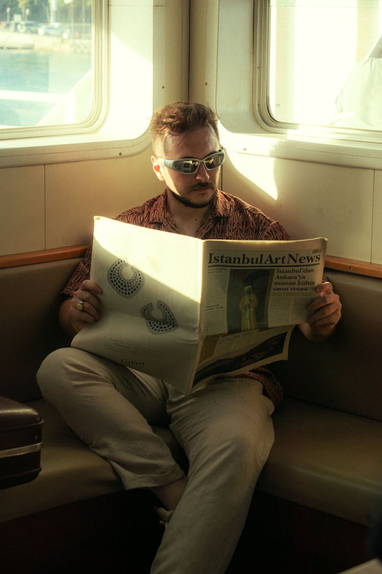 A Man Sitting With A Newspaper