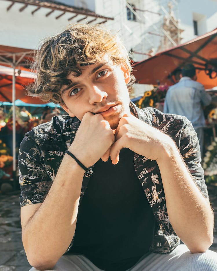 Young Man Posing At A Market In Aloha Shirt And Black T-Shirt