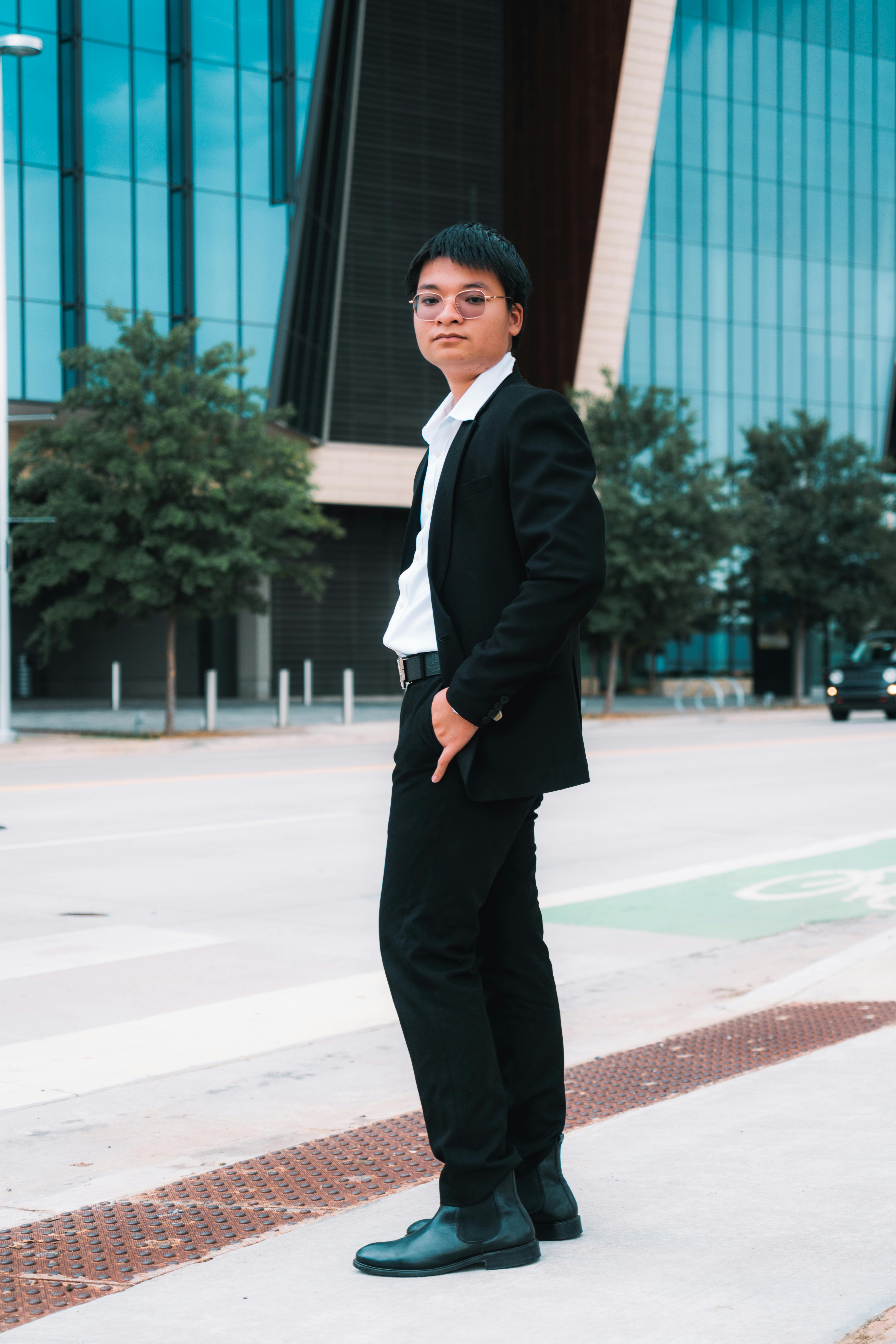 Confident young man in a suit standing on a city street, representing modern urban fashion.