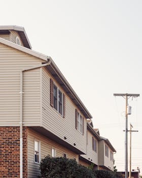 Contemporary suburban row houses with brick and siding exterior in a quiet residential area.