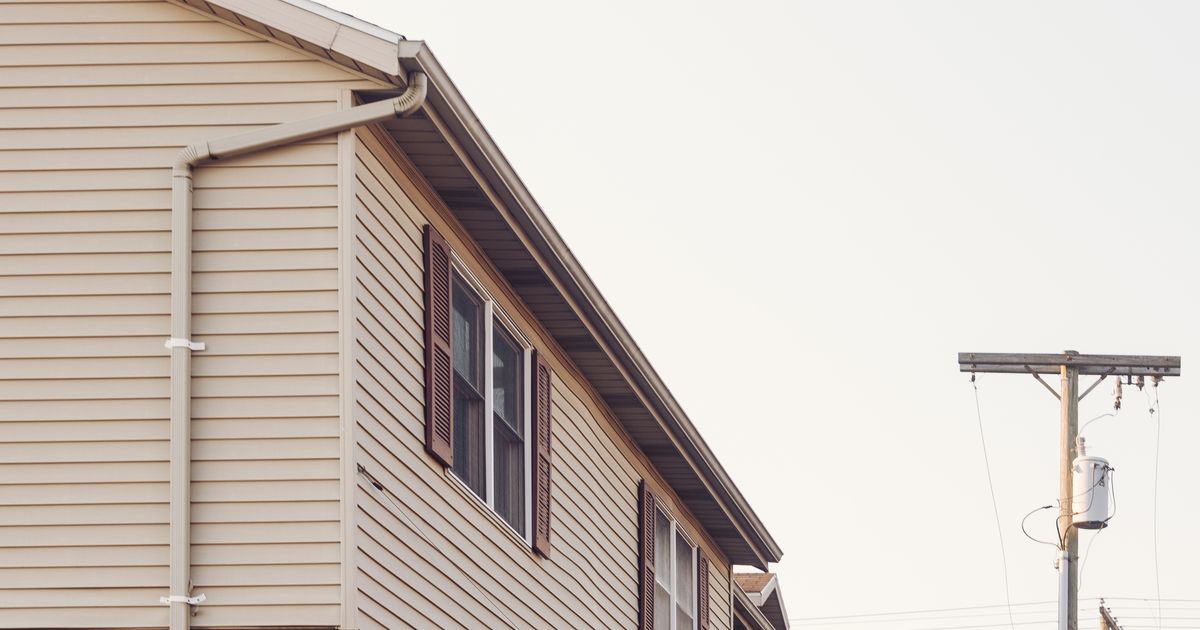 A row of suburban Maryland townhomes with brick and siding along a quiet residential street